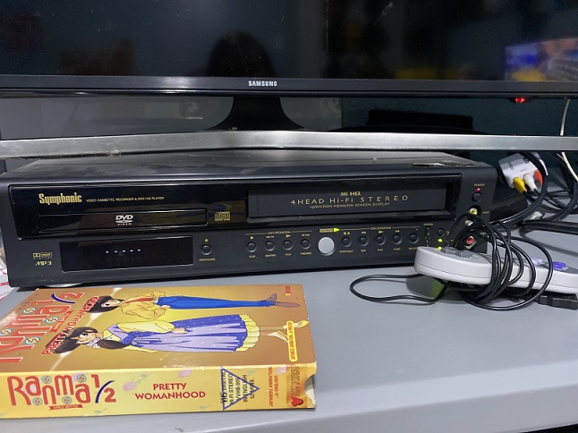 image of the VCR in question, with a Ranma 1/2 tape box on top of it, you can even see the adapter in the background that I use to let my PC connect to the TV, and theres a USB SNES controller in frame since it was there anyway